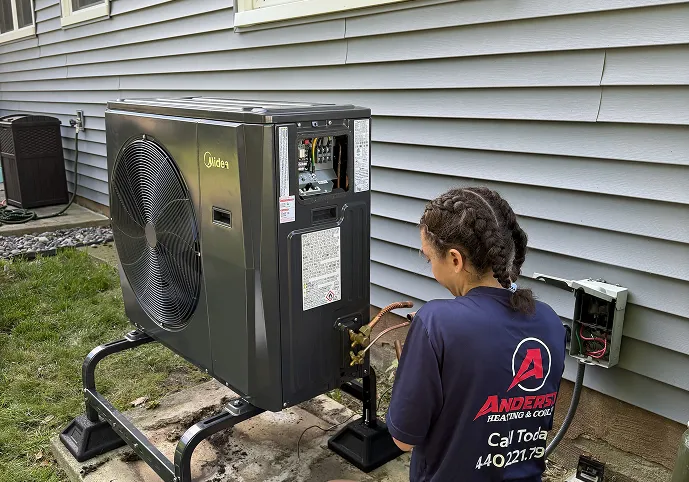Anderson technician checking the connections on a Midea heat pump outdoor unit