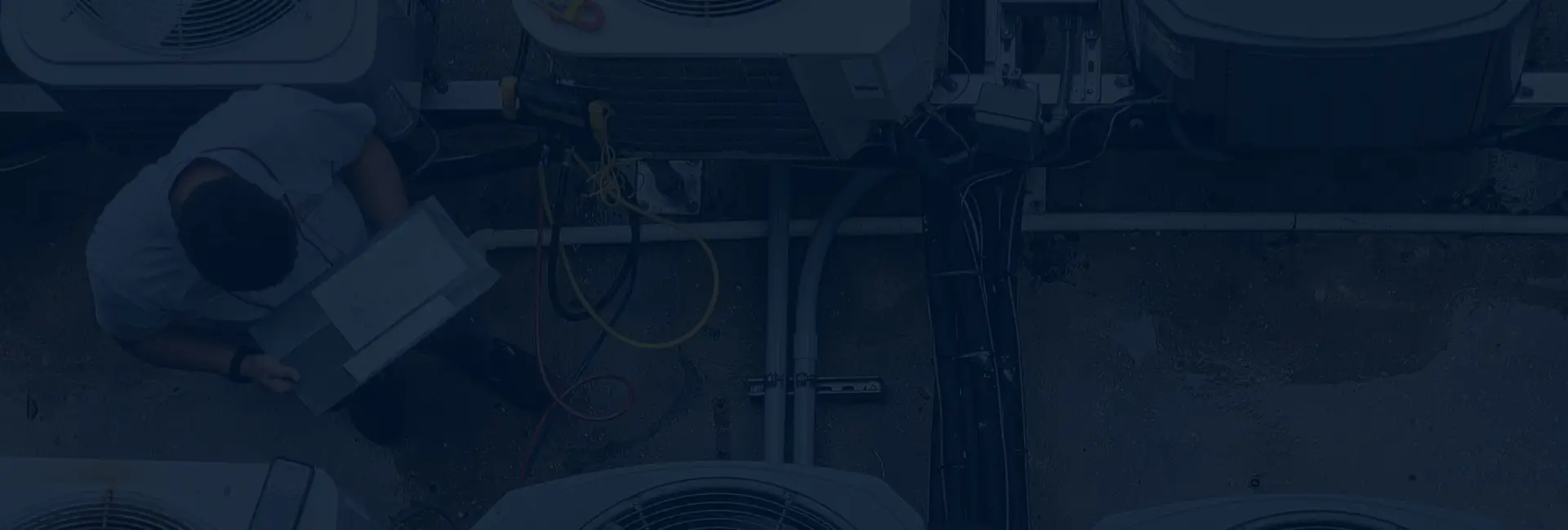 Technician with a clipboard among outdoor units, seen from above