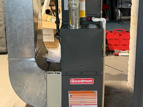 Goodman gas furnace connected to sheet-metal ductwork in a basement