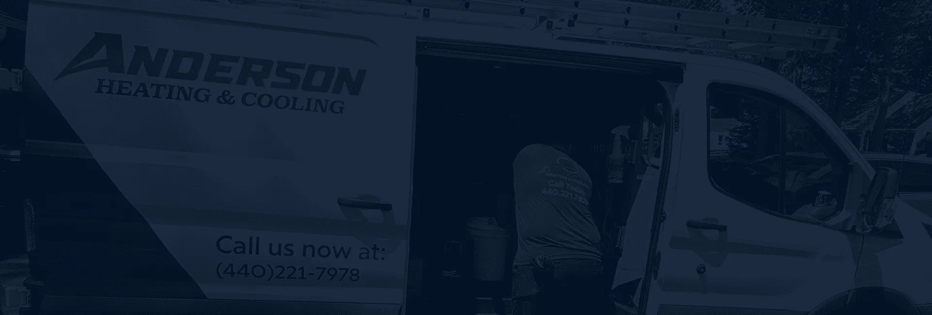 Anderson Heating and Cooling technician at the open side door of the company van