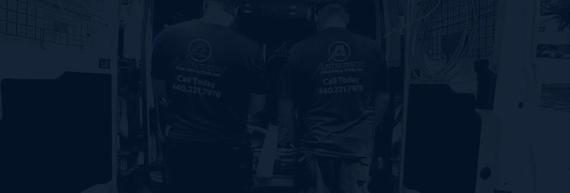 Two Anderson technicians with their backs to the camera at a service van
