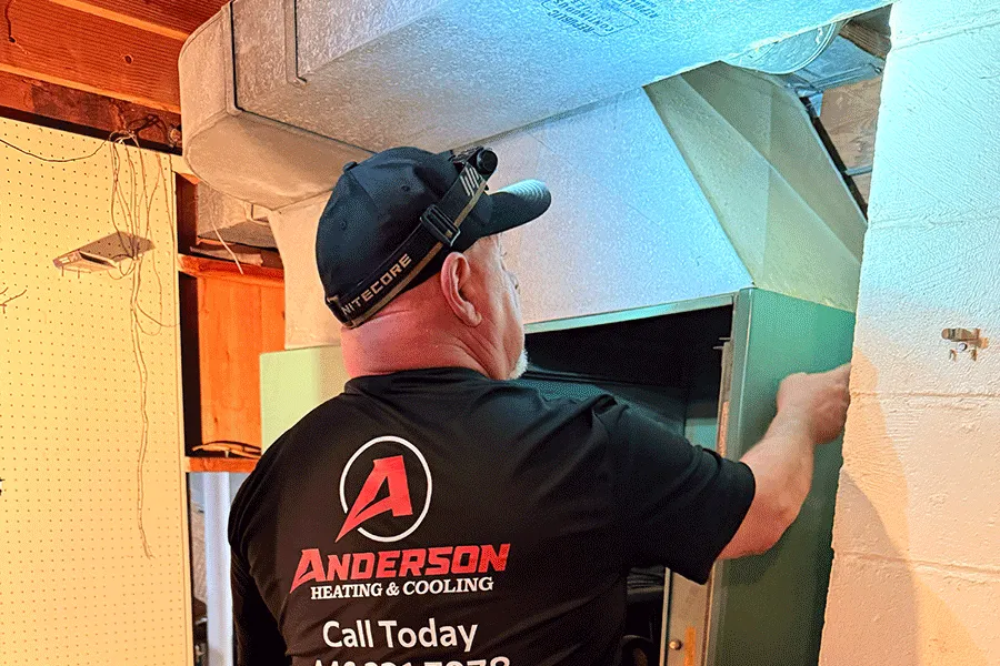 Anderson technician working on a furnace in a basement
